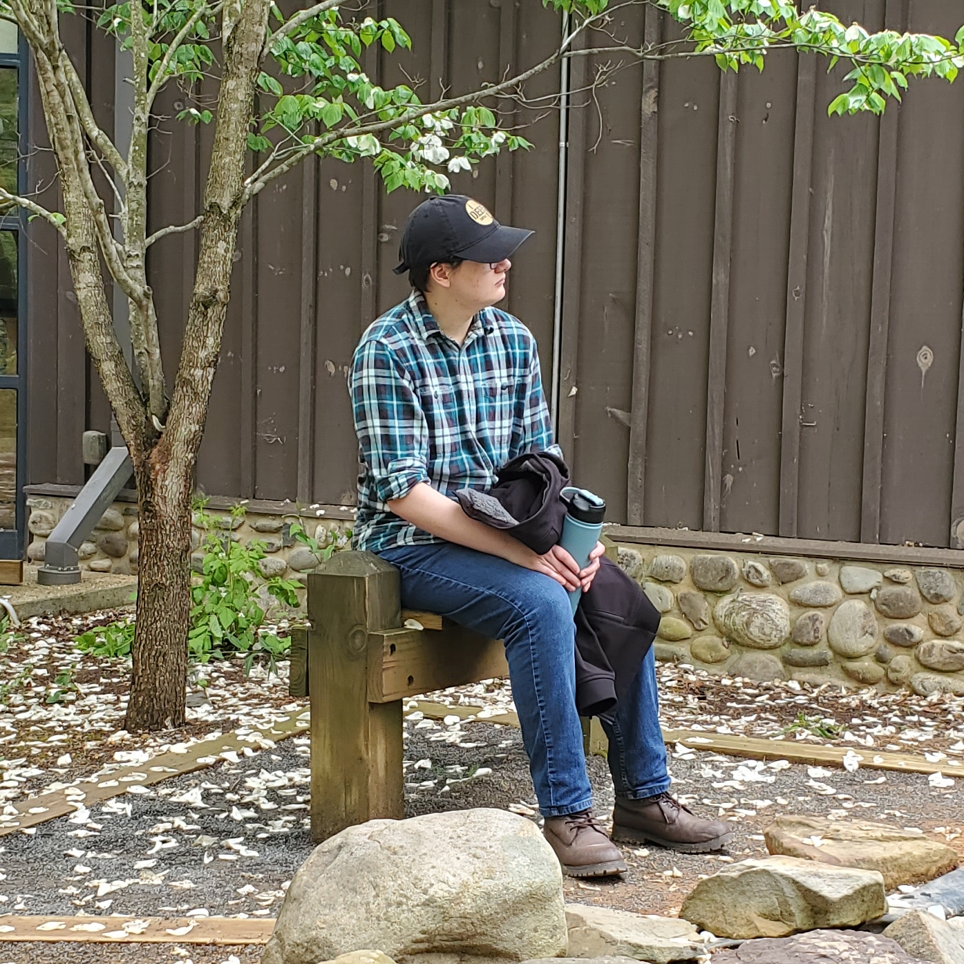 A photo of Damien sitting on a bench outside.